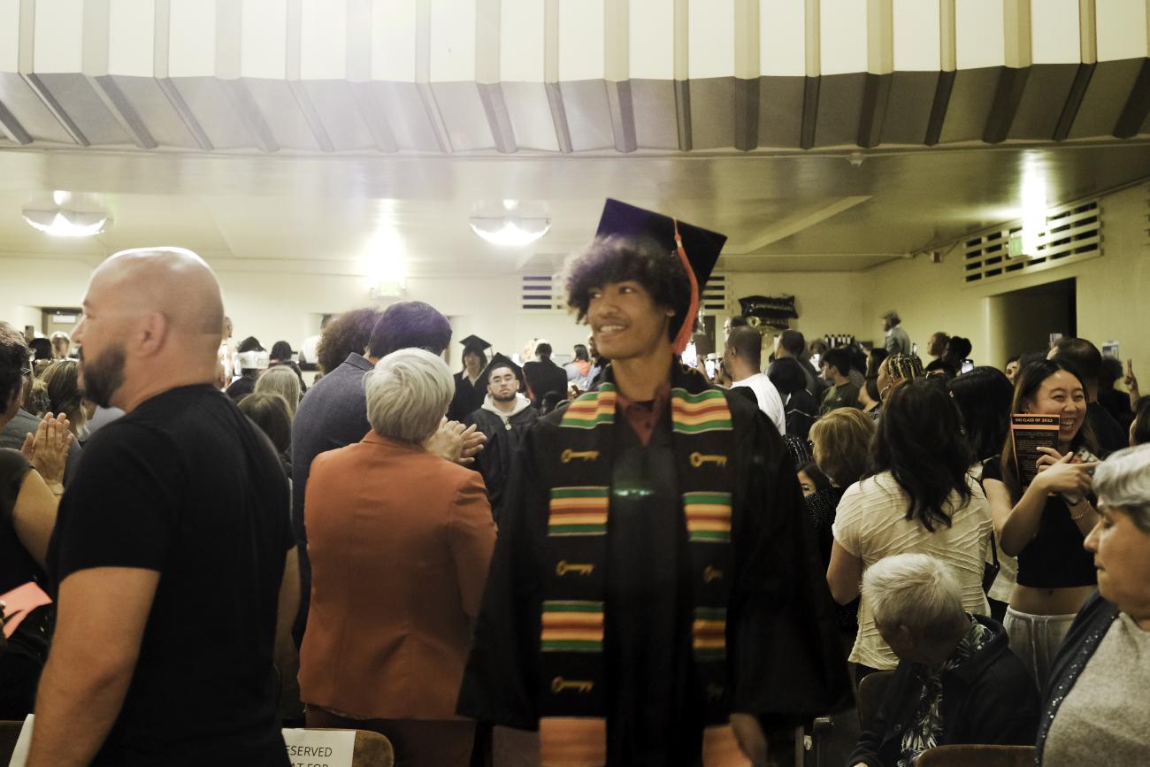 a graduate looks around a crowded room
